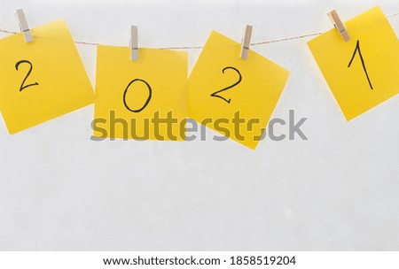 yellow stickers hang on a clothespin on a white background