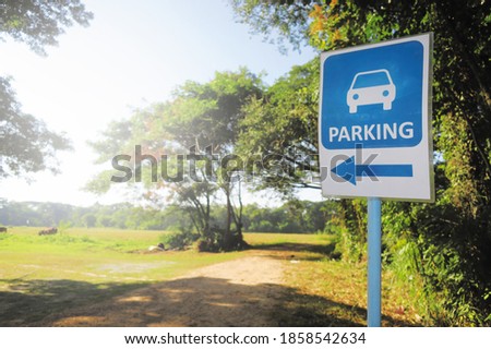 Car parking sign at the cpuntryside with forest tree and green wide lawn grass