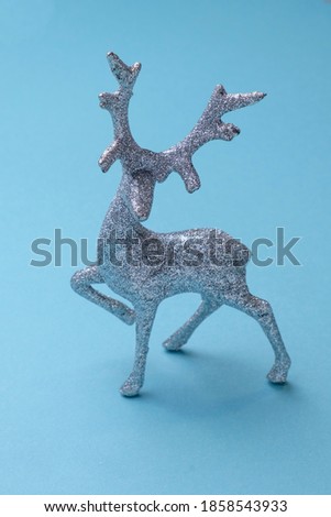 silver Christmas deer on a soft blue background, Christmas toy