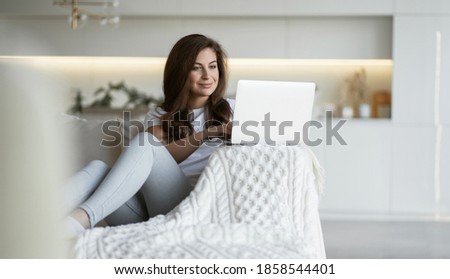 A woman makes online shopping gifts clothing gadget home shopping app website on a gadget laptop computer. buy online food products from a store near your home. Royalty-Free Stock Photo #1858544401