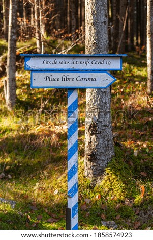 White-blue signpost indicating the direction to go. Corona free space or intensive care beds. Lettering in French language
