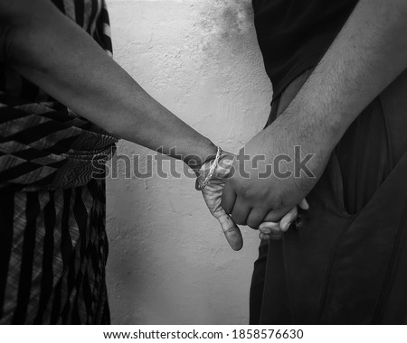 A Black and white image of two people holding hands on a rooftop with a grainy background - A monochrome image depicting a close bond between two people, understanding, love and support concept. 