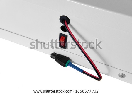 Red power switch in off position with power letter on. The wire is disconnected from the power supply.
