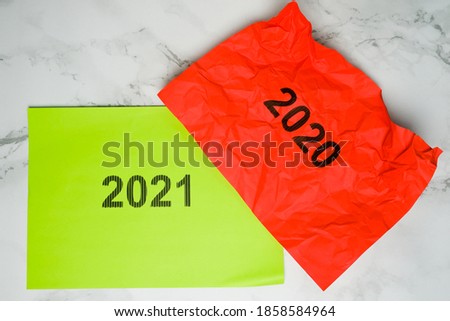 A picture of red crumpled paper with 2020, symbol as this year is disaster caused by Covid-19. Green paper with 2021 word symbol as the year will be new great year.