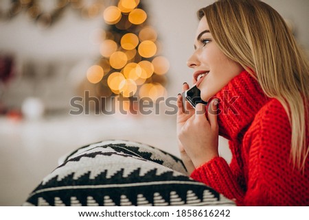 Young woman using phone on Christmas