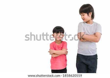 Short child boy in red t shirt and tall child boy in white t shirt standing arms crossed and looking face isolated on white background. Big and small kid concept at be friends. Different boy at tall. Royalty-Free Stock Photo #1858620559