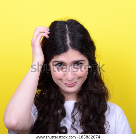 Portrait of beautiful girl thinking and scratching head against yellow background