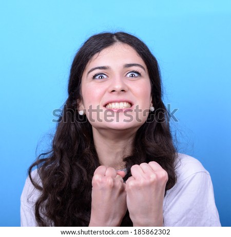 Portrait of angry girl against blue background