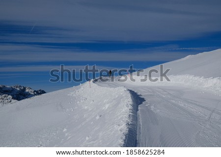 Silhouette of single skier on freshly groomed ski run on the slope on Monte Elmo / Helm, Sexten Dolomites, Italy