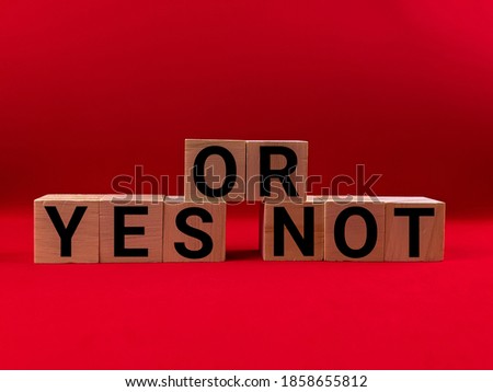 Wooden blocks letter alphabet "YES OR NOT" isolated with red background.