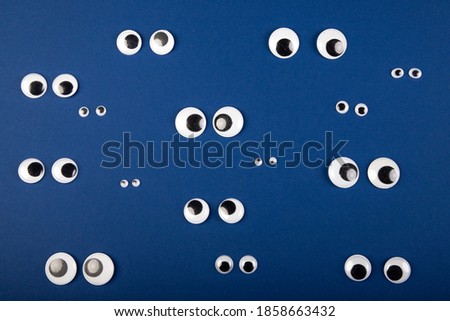 several eye couples on blue background, looking into different directions