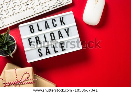 Black friday sale concept with present boxes, laptop and credit cards at red background. Online shopping. Top view.