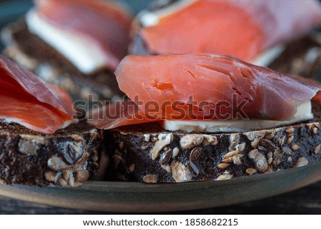 Fresh salmon sandwich, close up. Salted salmon and butter and dark bread on the plate