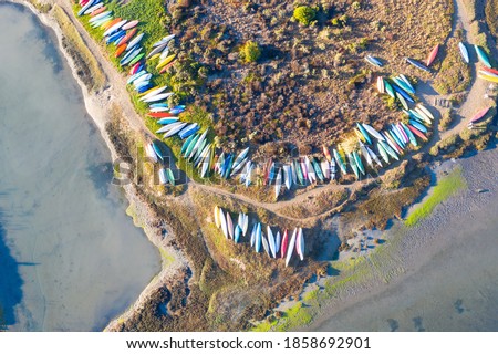 Colorful kayaks and small boats lie on the beautiful shoeline of Morro Bay in Central California. This region is known for its kayaking, sailing, surfing, fishing, and amazing coastlines.