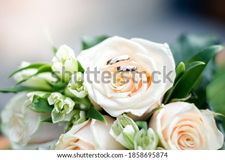 two wedding rings on a white rose bud, close-up bridal bouquet