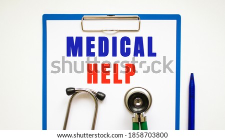 Clipboard with page and text MEDICAL HELP, on a table with a stethoscope and pen.