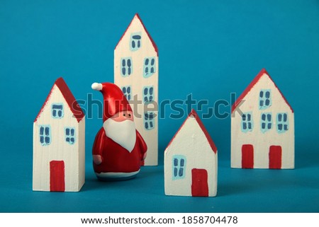 Santa Claus walking among houses of toy city - new year concept. Image contains copy space