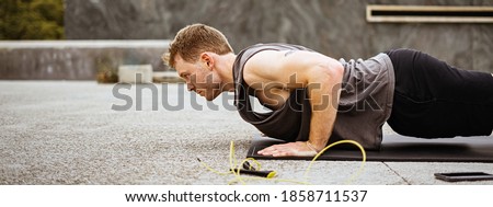 Picture of a fit young man doing push ups. Athlete doing fitness training outdoors. Workout during lockdown outside the gym.
