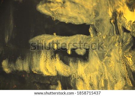 Black and yellow pigments difusion into each other Abstract colorful vivid background.