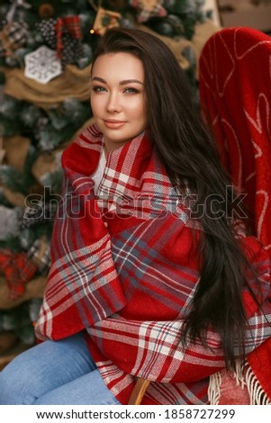 Christams cozy portrait of beautiful asian woman sitting at balcony backyard with new year decoration. Smiling pretty girl outdoors at Christmas interior. Concept of Christmas eve