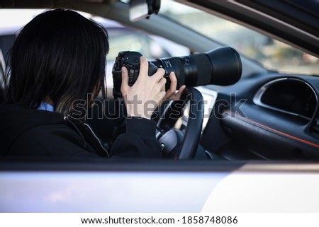 Woman taking pictures from inside the car