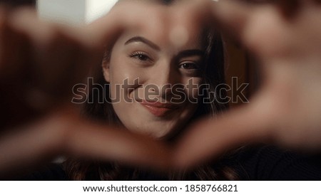 Young charming pretty smile face girl looking at camera and making heart sign with her hand, health insurance and valentines day concept