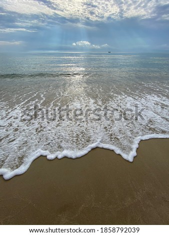 Sand beach with white foamy and wave from the sea