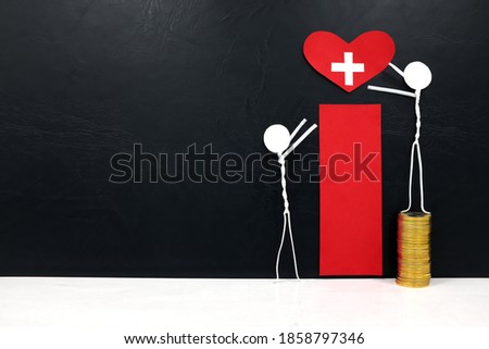Stick man figure reaching for a red heart shape with cross cutout while stepping on stack of coins. Health, healthcare, medical care and hospital access inequality concept