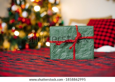Gift box tied with a red ribbon on the background of Christmas lights with a copy space