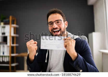 Holding Paycheck Or Payroll Check Or Insurance Cheque In Hand Royalty-Free Stock Photo #1858874629