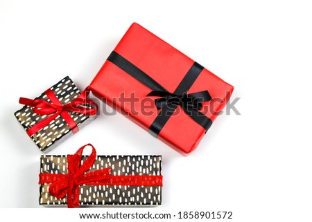 Gifts wrapped with colorful paper and red and black bows on white background