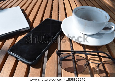 Work in travel conception. Laptop, mobile phone, sunglasses,  cup of coffee  on table. wood background texture.