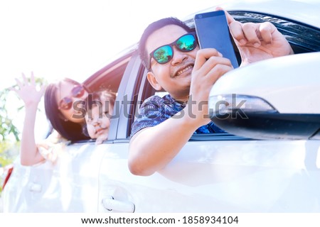 Happy asian family taking selfie in car
