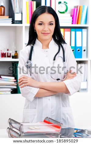Smiling doctor woman with arms crossed, looking at camera