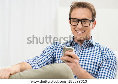 Portrait Of Young Man Listening To Music With IPod Royalty-Free Stock Photo #185899313