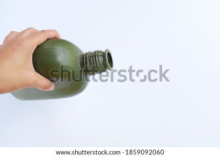 female hand holding Green army water canteen isolate on a white background.