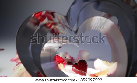 red heart in the center of metal hearts and rose petals