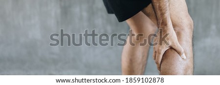 Young man having calf ache and problem leg injury with copy space for background