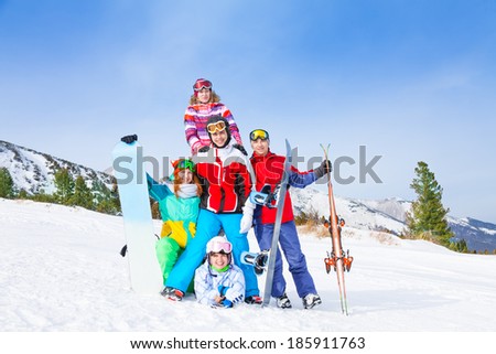 Cheerful guys standing with snowboards and skis