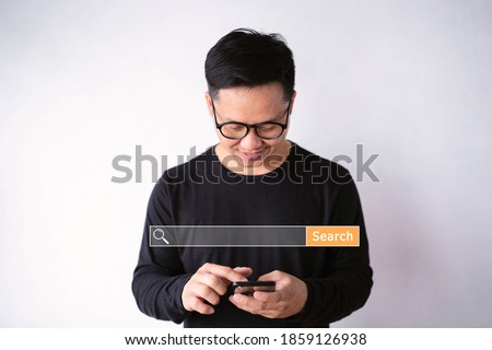 Asian men use smartphones to find what they are interested in. Searching information data on internet networking concept