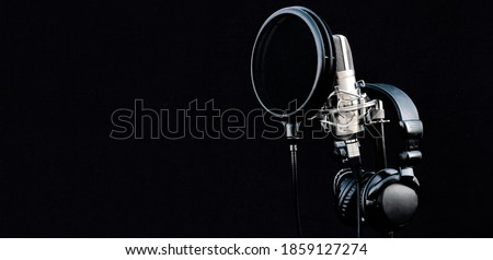 Mic condenser on mic stand with pop filter and headphones