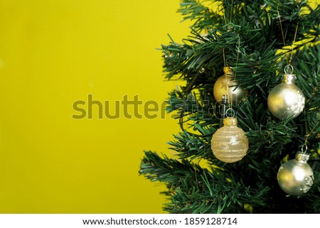 Christmas tree with white and beige shiny Christmas glass toys on a green background