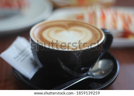 a cup of coffee with a picture of love in the coffee