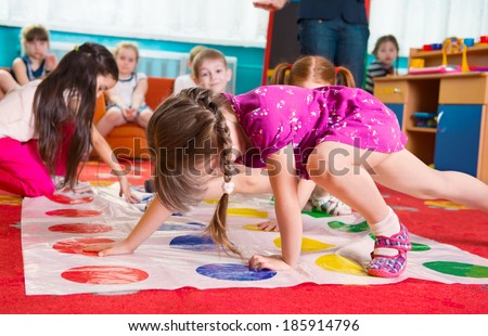 Cute toddlers playing in twister game at kindergarten Royalty-Free Stock Photo #185914796