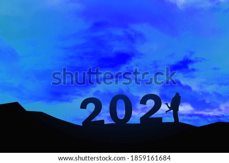 silhouette of miniature couple with text 2021  over blurred sky  background