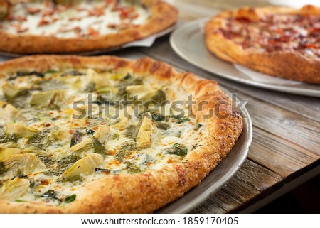 A view of a spinach and artichoke pizza.