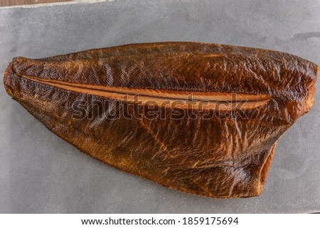 hot smoked halibut on a wooden board, against the background of a stone table top