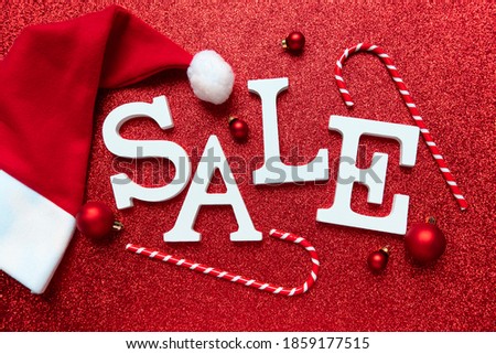 Winter Christmas sale white letters SALE on red festive shiny background. flat lay top view