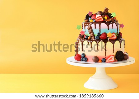 Cake on birthday with colorful rainbow cream on a yellow background decorated with berries, colorful sprinkles, poured with chocolate. Royalty-Free Stock Photo #1859185660