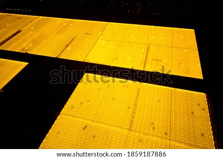 Glowing greenhouse roof at dusk, aerial photography